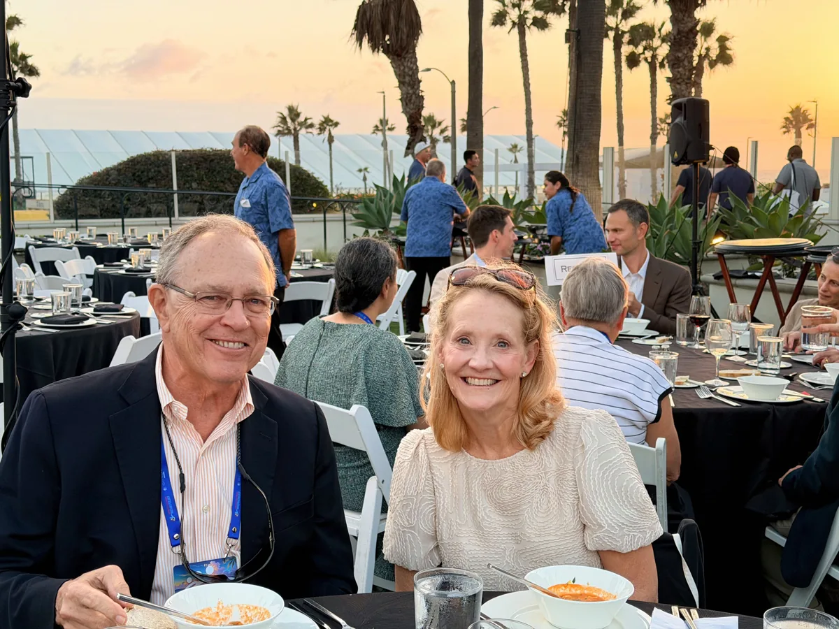 Two guests smiling at the outdoor awards banquet.