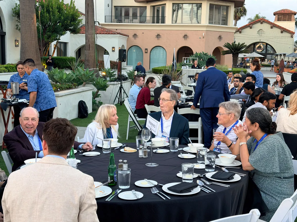 Faculty and attendees sharing a conversation over dinner.