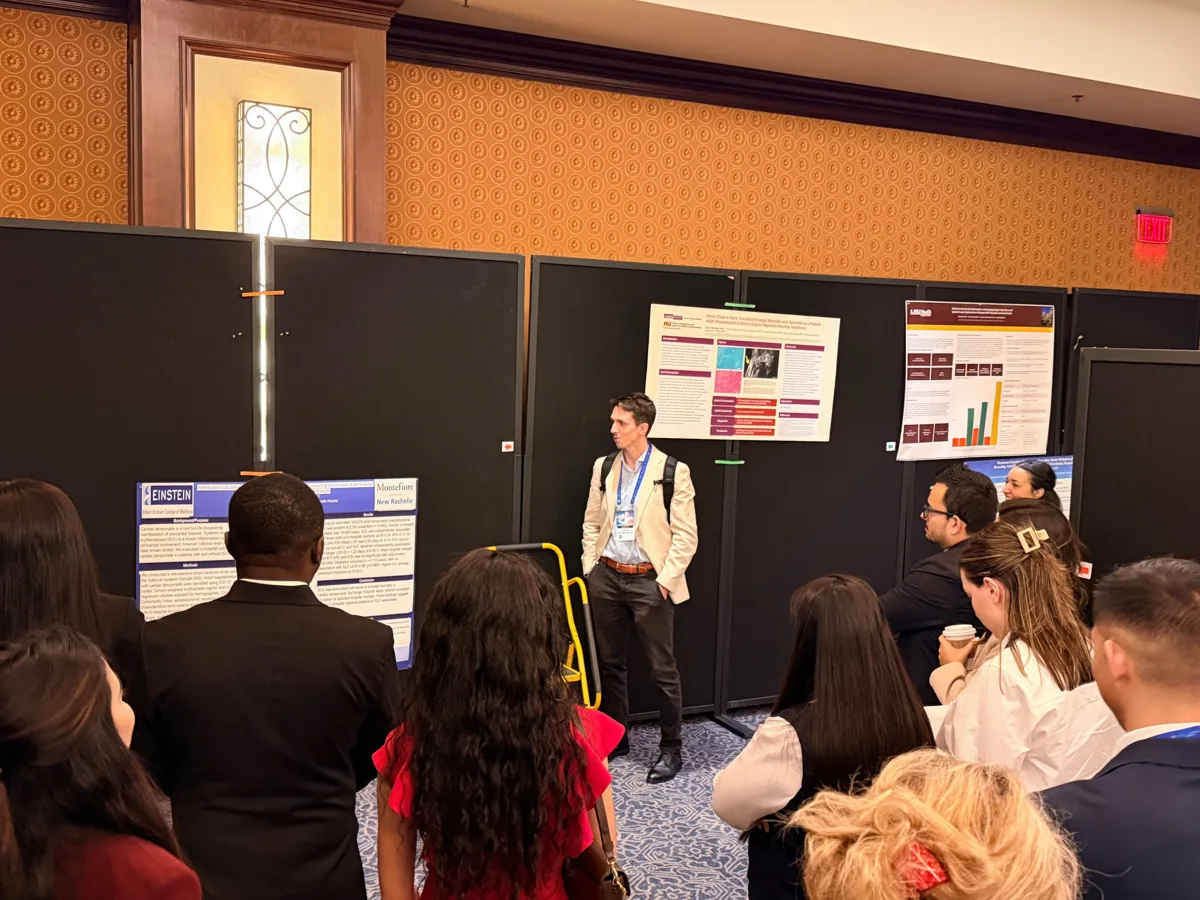 An investigator addressing a group during poster rounds.