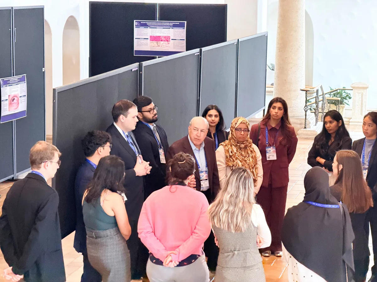 A small group gathered around an investigator during poster rounds.